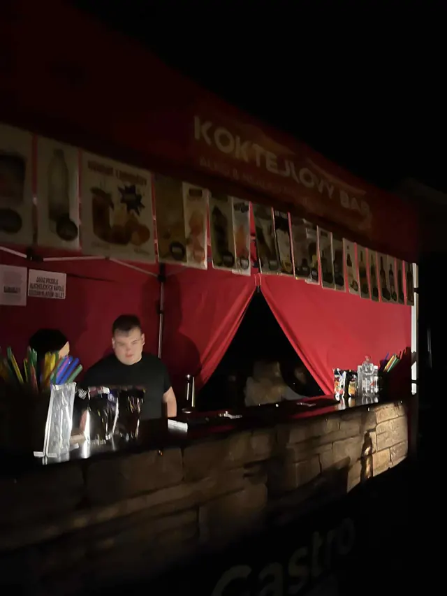 Barman za pultem večerního koktejlového baru